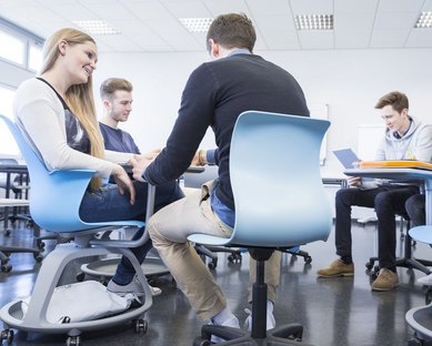 Lernmobiliar blaue Stühle mit Studierenden