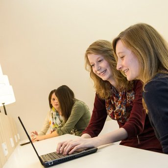 Studentinnen am Laptop in der Bibliothek